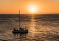 Group of unknown tourists on catamaran with lowered sails wait for Golden Sunset at crystal clear skies, CaribbeanÃÂ Sea, Jamaica Royalty Free Stock Photo